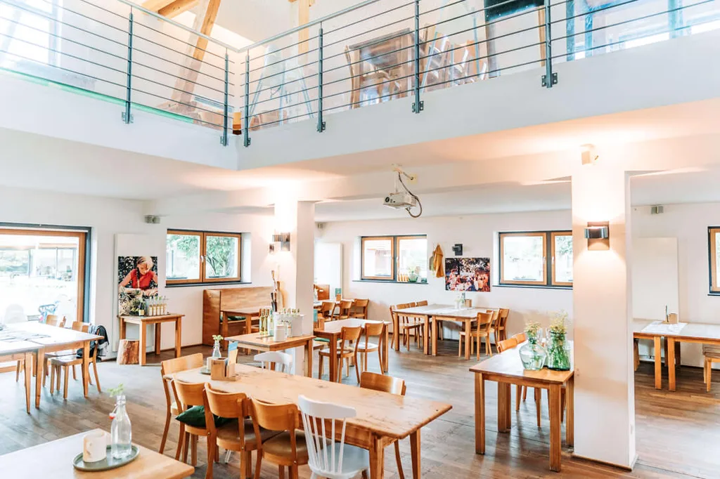 Salle lumineuse du restaurant familial Gut Hügle avec tables en bois